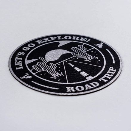 Black and Silver Faux Leather Go Explore patch laid at a hard angle