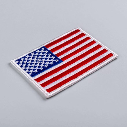 Embroidered American Flag Patch with white border laid at a hard angle