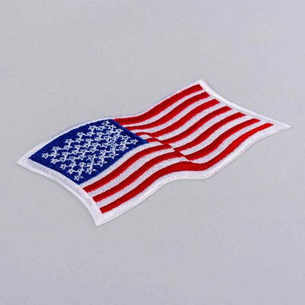 Embroidered Wavy American Flag Patch with white border laid at a hard angle