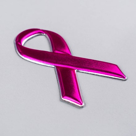 FlexStyle Metallic Pink Ribbon emblem laid at a hard angle