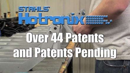 Stahls’ Hotronix – over 44 patents and patents pending. Man constructing presses in the background of text.