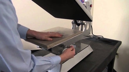 Close up of person adjusting a Hotronix Auto Clam Heat Press's knob